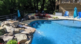 Freeform pool with rock waterfalls, tanning ledge and  swim up bar stools