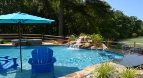 Freeform pool with pool chairs and umbrella