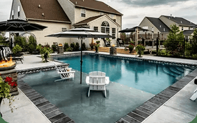 Custom inground pool with patio and fire feature by Blue Tree Outdoor Living