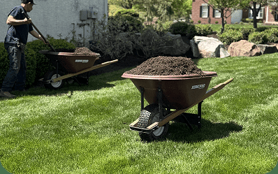 Blue Tree crew spreading mulch in landscape beds