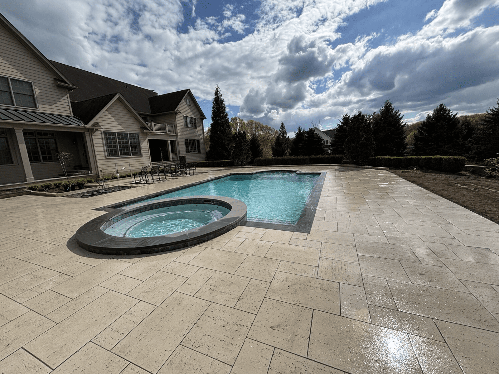 Finished pool, spa, and travertine patio in Collegeville, Pennsylvania by Blue Tree Outdoor Living
