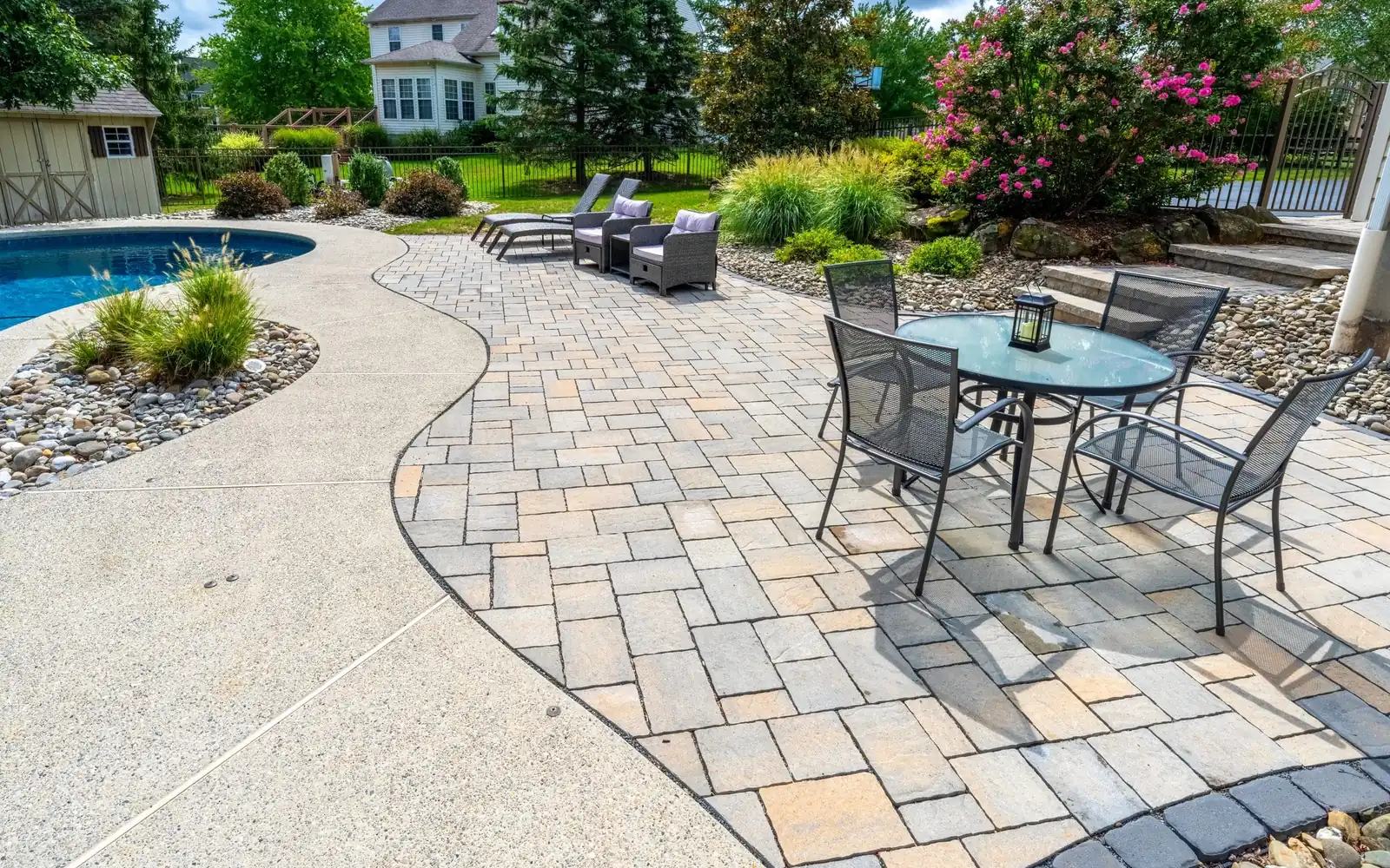 Backyard patio, pool, lawn, and plantings designed as one outdoor living space by Blue Tree Outdoor Living