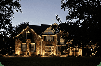 Home exterior with landscape lighting installed by Blue Tree at dusk