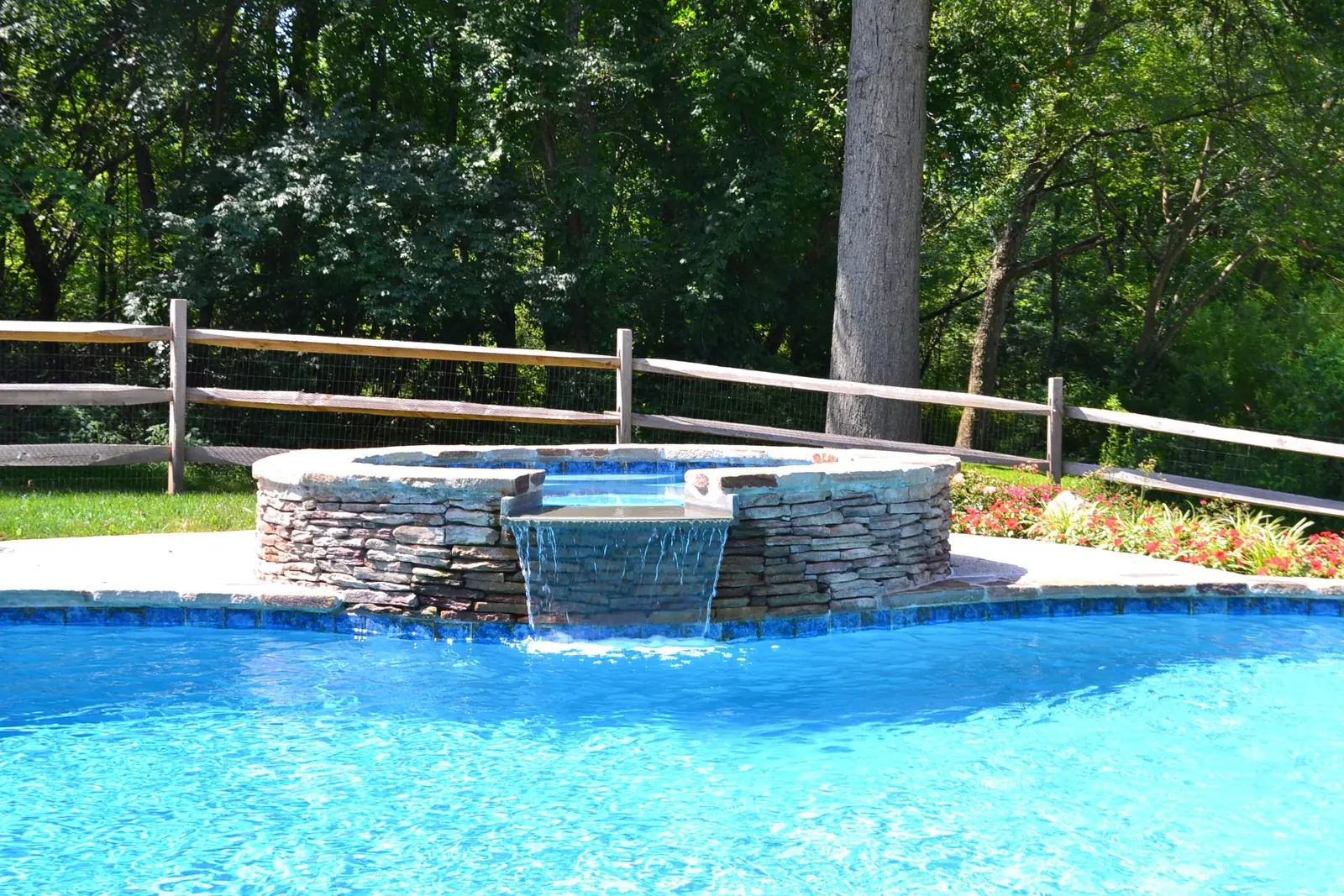 Raised spa with a spillway into a custom pool in Phoenixville, PA