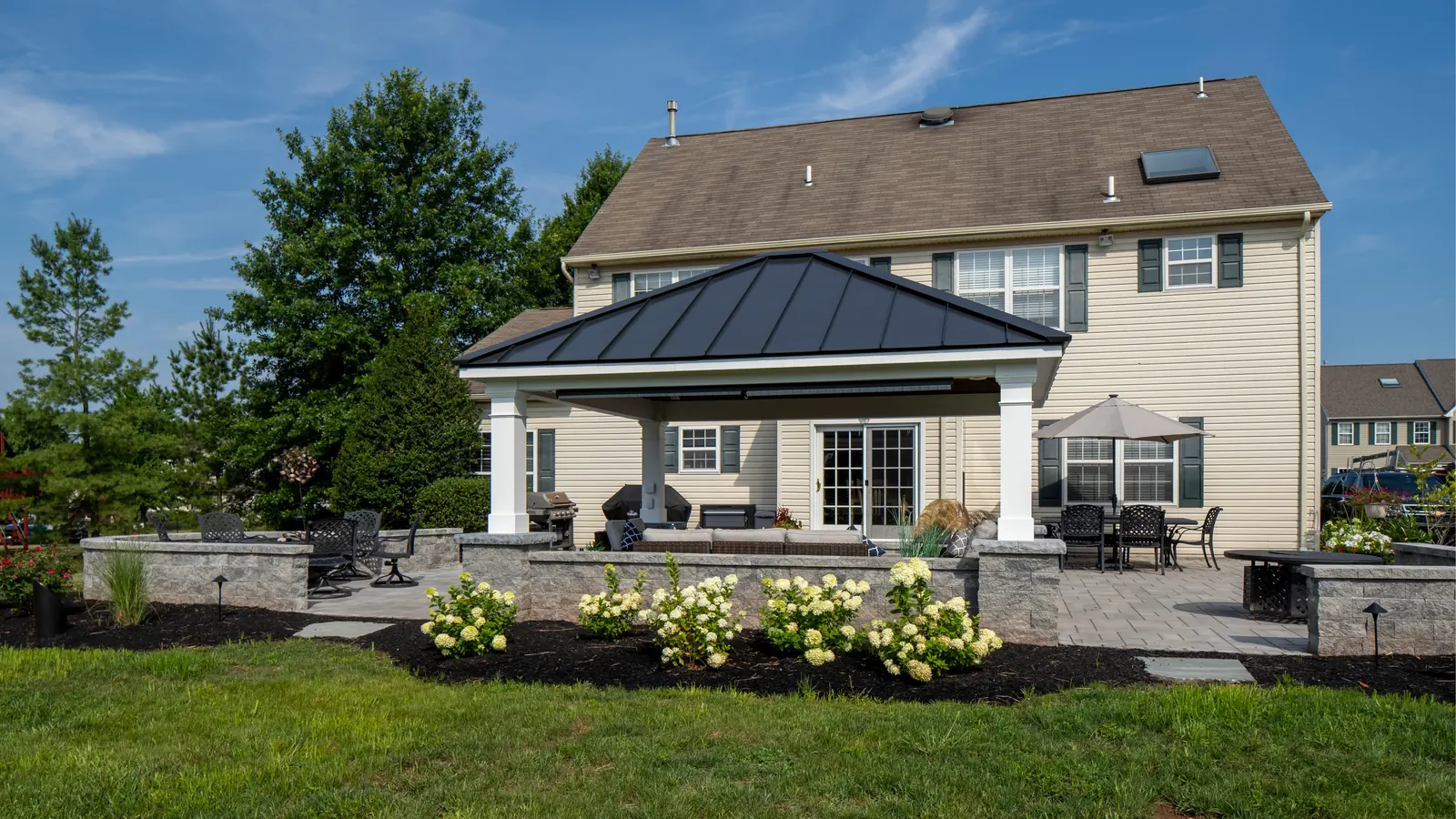 Roofed patio, sitting walls, and landscape plantings in Skippack, PA