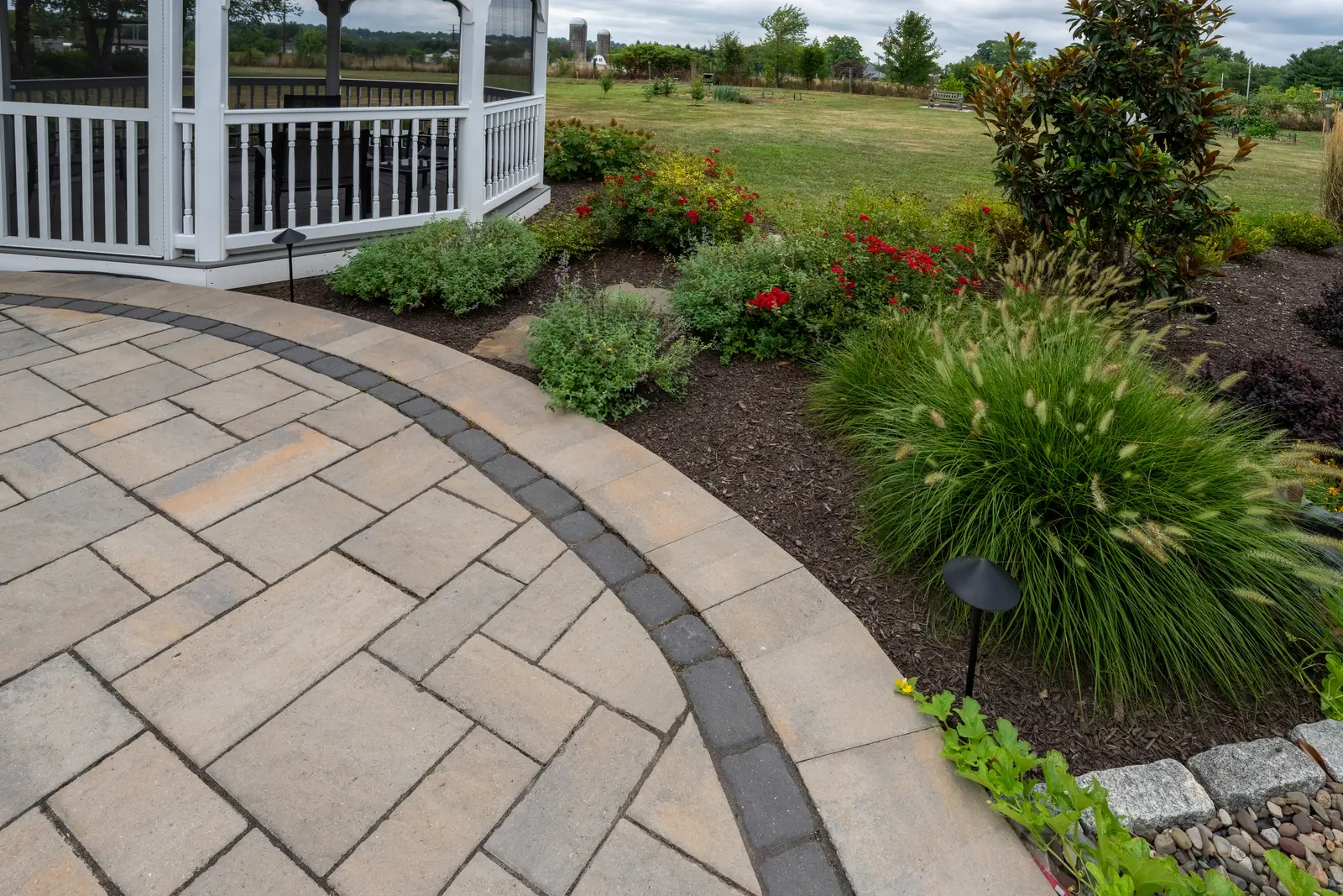 Paver border, planting bed, and landscape light beside a Telford patio