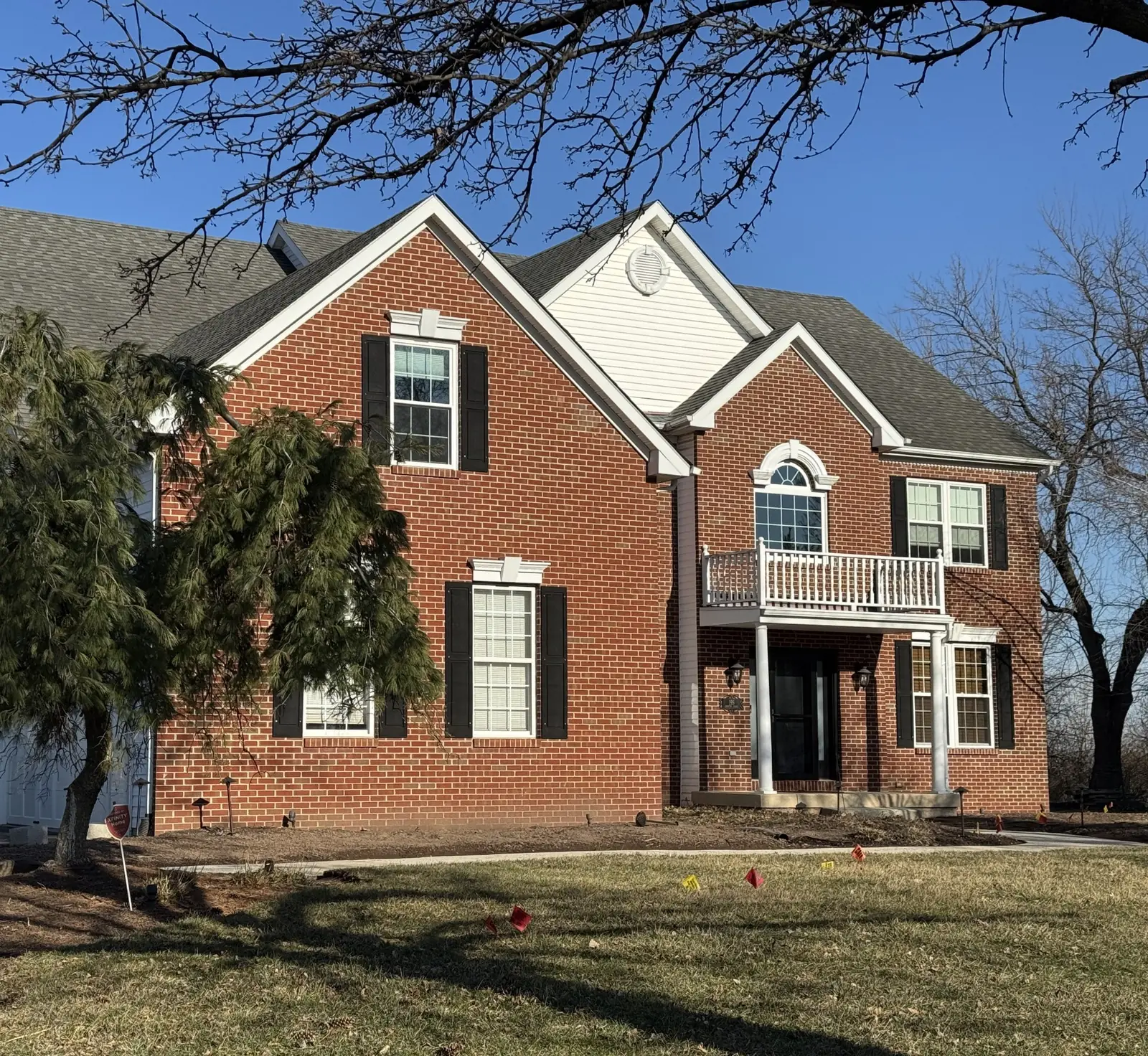 Front of a brick home before landscape installation in Upper Providence, PA