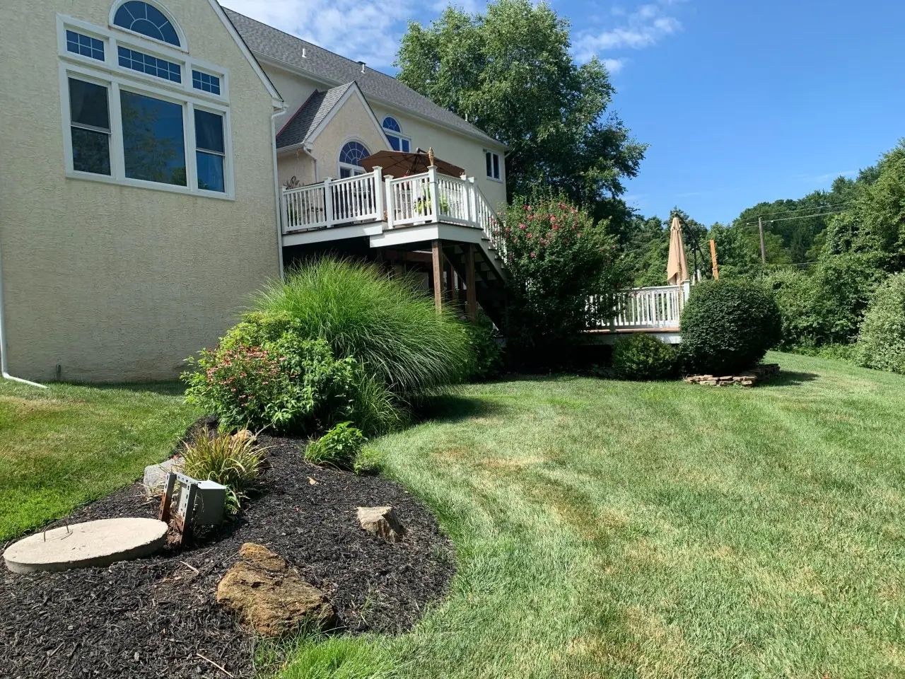 Sloped backyard and raised deck before pool construction in West Chester, PA